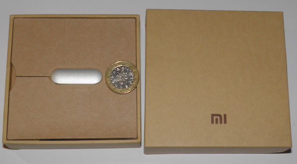 Xiaomi Mi Band: Der Tracker in der Schachtel, zum Größenvergleich mit 1-Euro-Stück